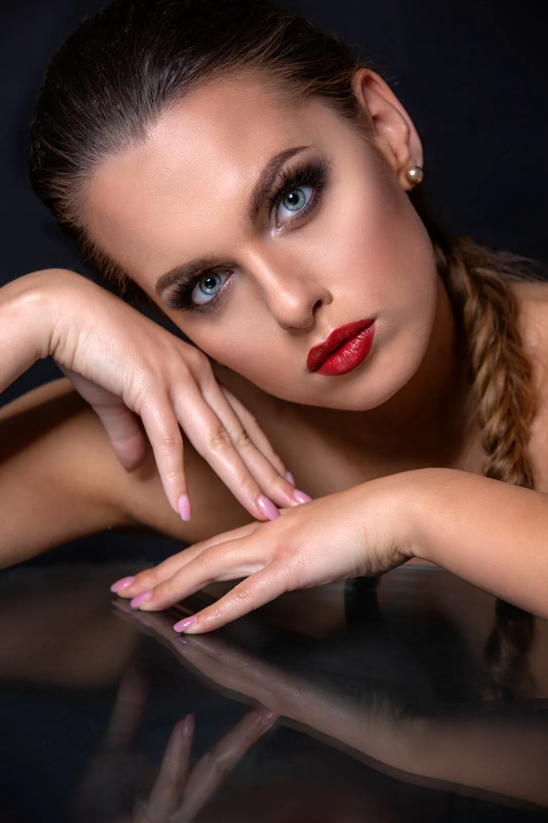 Beauty portrét s výraznými očami, červenými perami a uhladeným účesom.